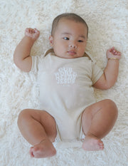 Our World Needs Jesus Beige Onesie Christian Baby Clothing